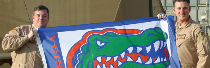 men in uniform hold gator flag