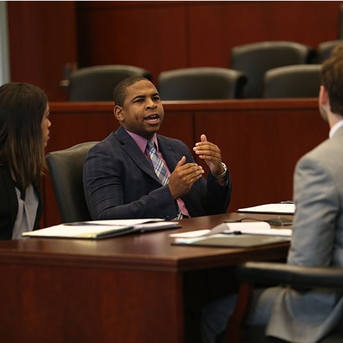 Photo of Students at desk discussing