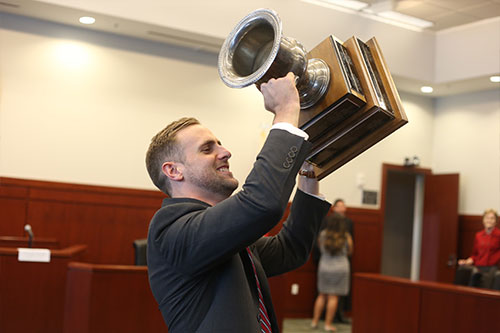 Student triumphantly holding trophy