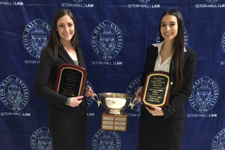 Students holding trophy and plaques